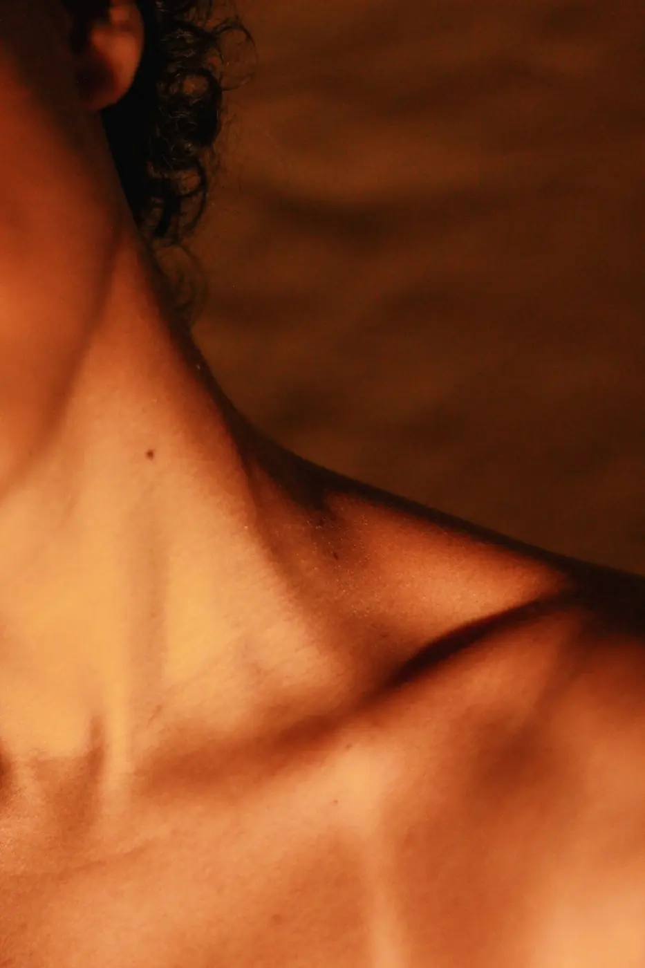 Clavicule et cou hâlés, lumière chaude